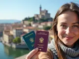 Uśmiechnięta kobieta trzyma paszporty na tle włoskiego miasta. Czy do Włoch potrzebny jest paszport? Tak, jeśli podróżujesz spoza strefy Schengen.