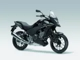 Czarny motocykl Honda CB500X z przyciemnianą szybą i srebrnym wydechem, gotowy na przygodę.