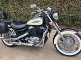 Czarny motocykl Honda Shadow 1100 z kremowym bakiem i sakwami. Idealny na długie trasy, sprawdź honda shadow 1100 dane techniczne.