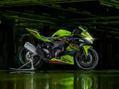 Zielono-czarny motocykl Kawasaki Ninja ZX4RR na stojaku, z odbiciem w kałuży.