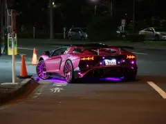 Różowy Lamborghini z neonowym podświetleniem na ulicy nocą.