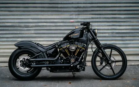 Czarny Harley-Davidson Dyna z błyszczącym lakierem i złotymi akcentami na silniku, gotowy do drogi.