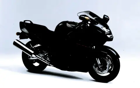 Czarny motocykl Honda CBR1100XX, sportowy turystyk, gotowy na dalekie podróże.