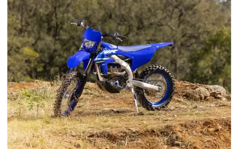 Niebieski motocykl Yamaha WR250F na tle leśnym. Szczegółowe yamaha wr 250 f dane techniczne dostępne dla miłośników off-roadu.