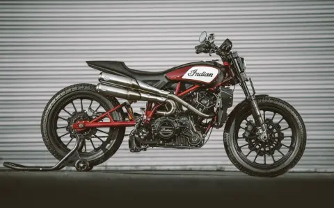 Stylowy Indian FTR 1200 w kolorze czerwono-białym, z podwójnym wydechem i czarnymi felgami, gotowy do jazdy.