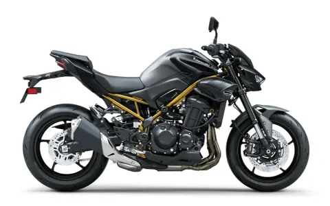 Stylowy, czarny Kawasaki Z900 z widoczną złotą ramą, gotowy na podbój dróg.
