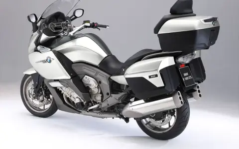 Srebrny motocykl BMW K1600GTL z kuframi i podnóżkami. Idealny do długich podróży, sprawdź jego bmw k1600gtl dane techniczne.