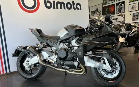 Czarny motocykl Bimota Tesi H2 z włókna węglowego, z podwójnym wydechem i sportowym zawieszeniem, gotowy do jazdy.
