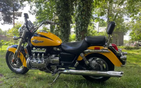 Żółta Honda Valkyrie 1500, z chromowanymi elementami i potężnym silnikiem, zaparkowana na trawie. Dane techniczne tego klasyka budzą podziw.