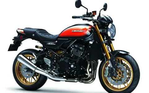 Stylowy motocykl Kawasaki Z900RS w kolorze czarnym z pomarańczowymi akcentami i złotymi felgami. Klasyka w nowoczesnym wydaniu.