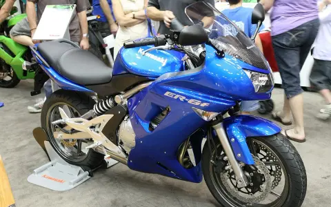 Błękitny motocykl Kawasaki ER-6f, z widocznymi danymi technicznymi na owiewce, prezentowany na wystawie.