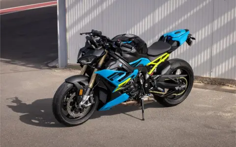 Potężny motocykl BMW S1000R w jaskrawych kolorach niebieskim i żółtym, gotowy do jazdy po torze.