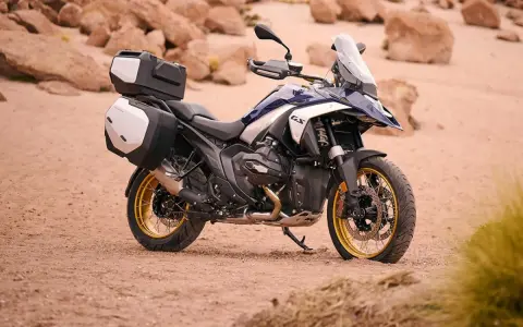 Nowy motocykl BMW R1300GS z kuframi, gotowy na przygodę po pustynnych terenach.