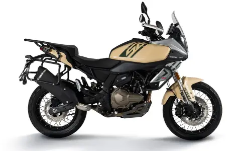 Beżowy motocykl turystyczny z bagażnikami, gotowy na dalekie wyprawy.