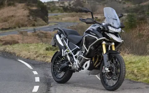 Czarny motocykl Triumph Tiger 1200 na tle krajobrazu. Poznaj jego imponujące triumph tiger 1200 dane techniczne.