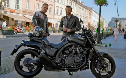 Dwóch mężczyzn pozuje obok czarnego motocykla Yamaha V-Max 1700 na ulicy.