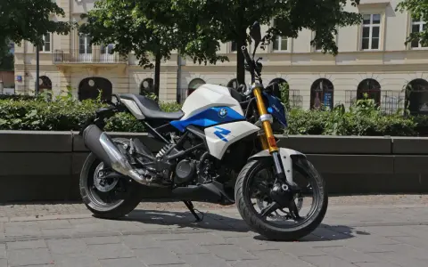 Biało-niebieski motocykl BMW G 310 R na tle kamienicy. Sprawdź jego dane techniczne!