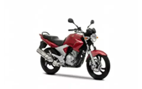 Czerwony motocykl Yamaha YBR 250 z czarnym siedzeniem i srebrnym wydechem, gotowy do jazdy po mieście.