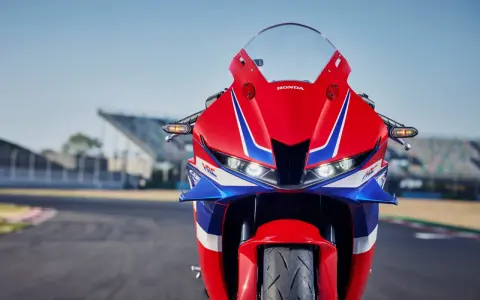 Czerwono-niebieski motocykl Honda CBR 600RR na torze wyścigowym. Poznaj honda cbr 600rr dane techniczne i poczuj moc!