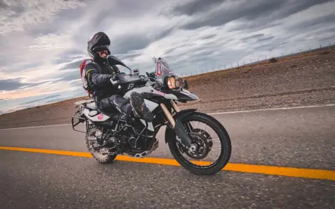 Motocyklista na BMW GS 800, mimo potencjalnych wad, cieszy się jazdą po pustej drodze.
