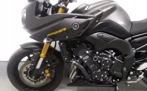 Ciemnoszary motocykl Yamaha FZ8 z żółtym napisem "FAZER" na owiewce. Widoczny silnik i przednie zawieszenie.