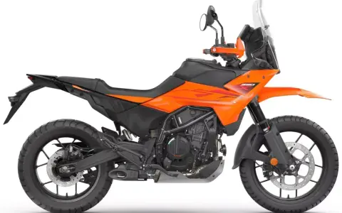 Pomarańczowy motocykl KTM 390 Adventure gotowy na przygodę.