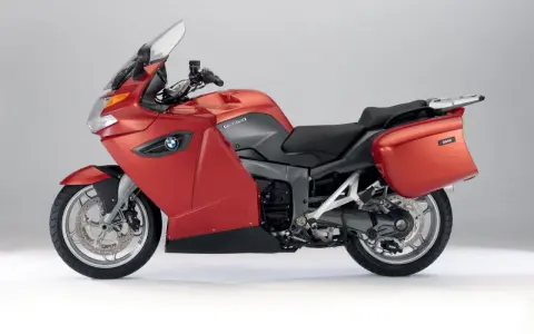Czerwony motocykl turystyczny BMW K1300GT z kuframi, gotowy na długie podróże.