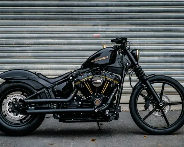 Czarny Harley-Davidson Dyna z błyszczącym lakierem i złotymi akcentami na silniku, gotowy do drogi.