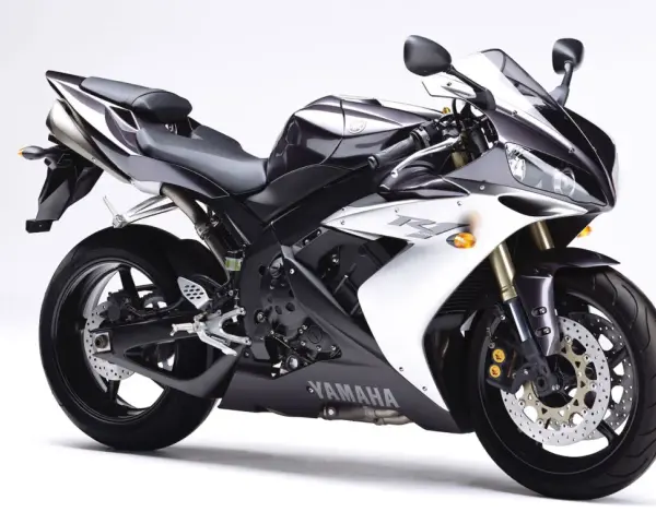 Sportowy motocykl Yamaha R1, jedna z wielu generacji, w kolorze czarno-białym, prezentuje się dynamicznie na białym tle.