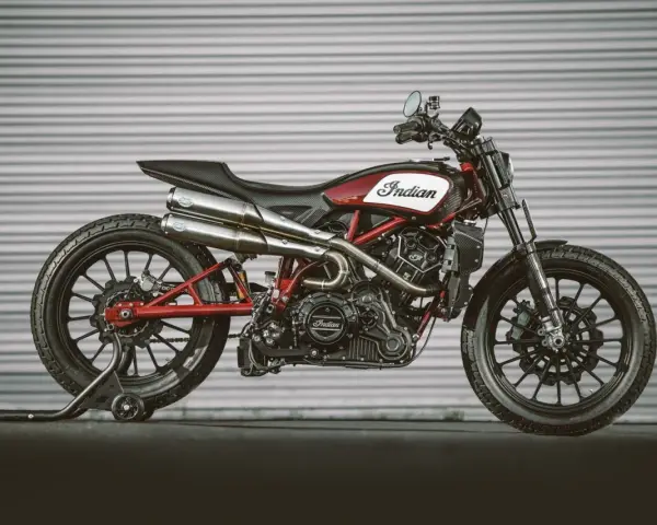Stylowy Indian FTR 1200 w kolorze czerwono-białym, z podwójnym wydechem i czarnymi felgami, gotowy do jazdy.
