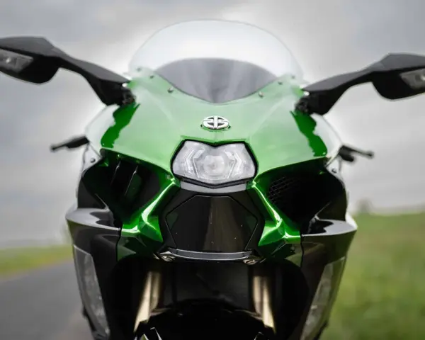 Przód zielono-czarnego motocykla Kawasaki Ninja H2 z błyszczącym logo i ostrymi liniami, gotowy do jazdy.