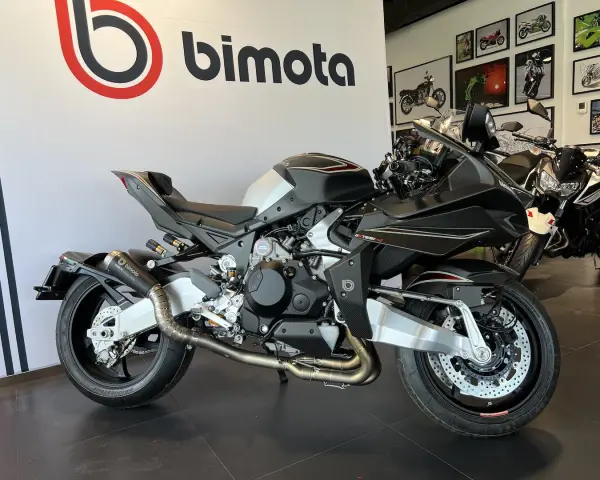 Czarny motocykl Bimota Tesi H2 z włókna węglowego, z podwójnym wydechem i sportowym zawieszeniem, gotowy do jazdy.