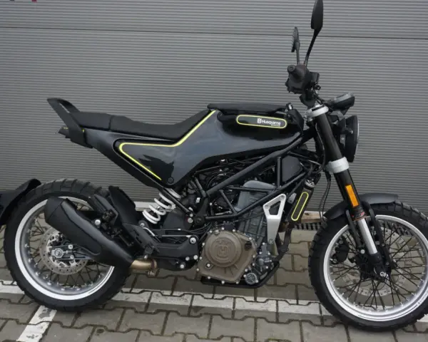 Czarny motocykl Husqvarna Svartpilen 401 z żółtymi akcentami, gotowy na miejskie przygody.