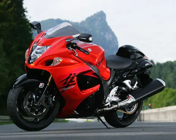 Czerwony motocykl Suzuki Hayabusa na drodze, z widokiem na góry. Poznaj jego suzuki hayabusa dane techniczne.