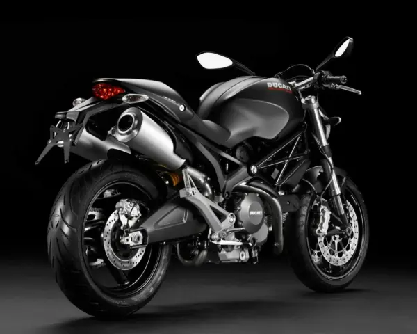 Czarny Ducati Monster 696 z podwójnym wydechem i sportowym wyglądem, gotowy do jazdy.