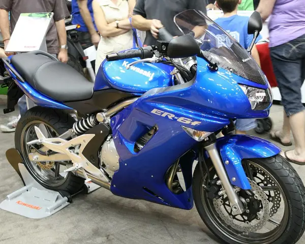 Błękitny motocykl Kawasaki ER-6f, z widocznymi danymi technicznymi na owiewce, prezentowany na wystawie.