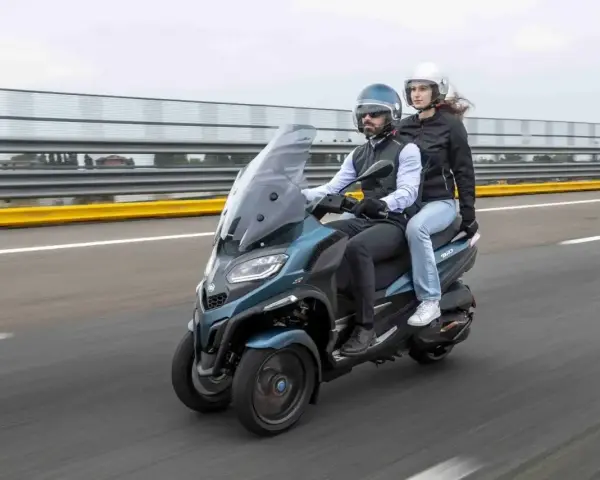 Para jadąca na Piaggio MP3 500, testująca jego prędkość maksymalną na torze wyścigowym.