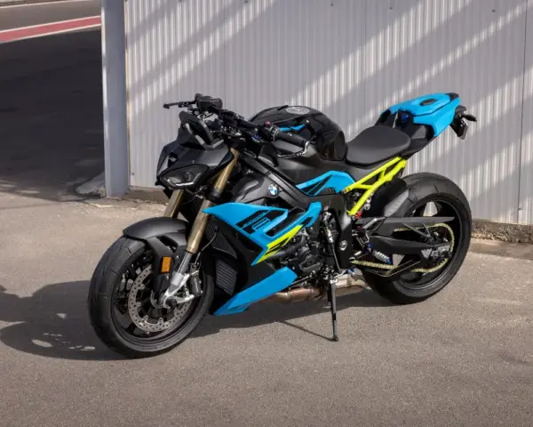 Potężny motocykl BMW S1000R w jaskrawych kolorach niebieskim i żółtym, gotowy do jazdy po torze.