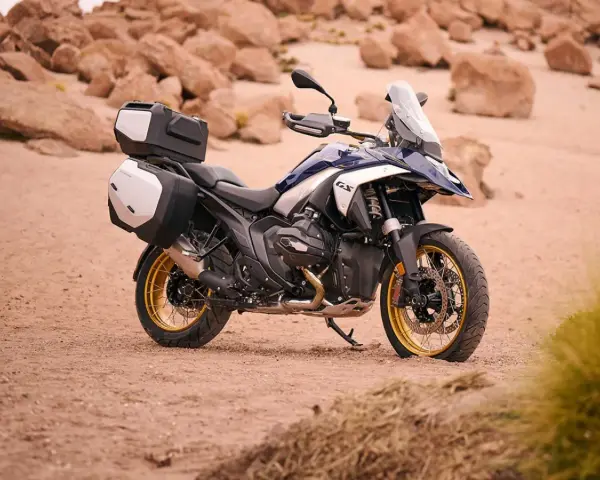 Nowy motocykl BMW R1300GS z kuframi, gotowy na przygodę po pustynnych terenach.
