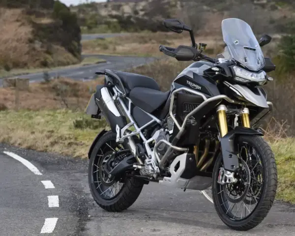 Czarny motocykl Triumph Tiger 1200 na tle krajobrazu. Poznaj jego imponujące triumph tiger 1200 dane techniczne.