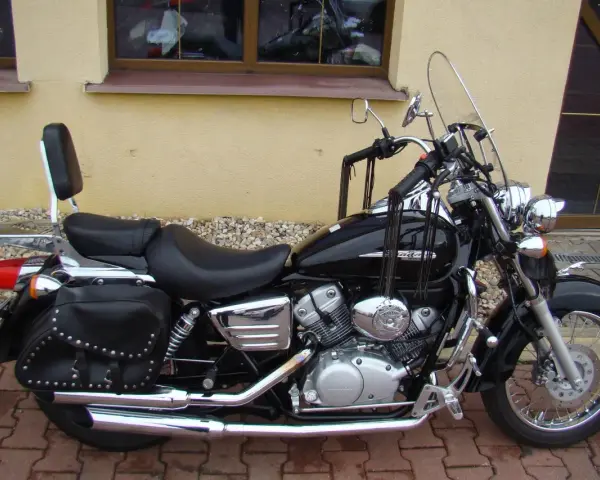 Czarny motocykl Honda Shadow 125, z sakwami i oparciem. Idealny na podróże, poznaj jego honda shadow 125 dane techniczne.