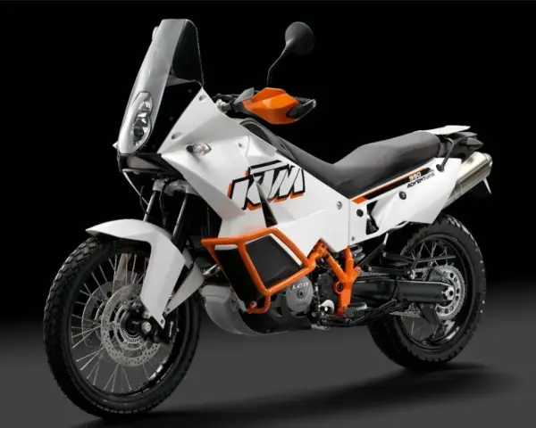 Biały motocykl KTM 990 Adventure z pomarańczowymi akcentami, gotowy na każdą przygodę.