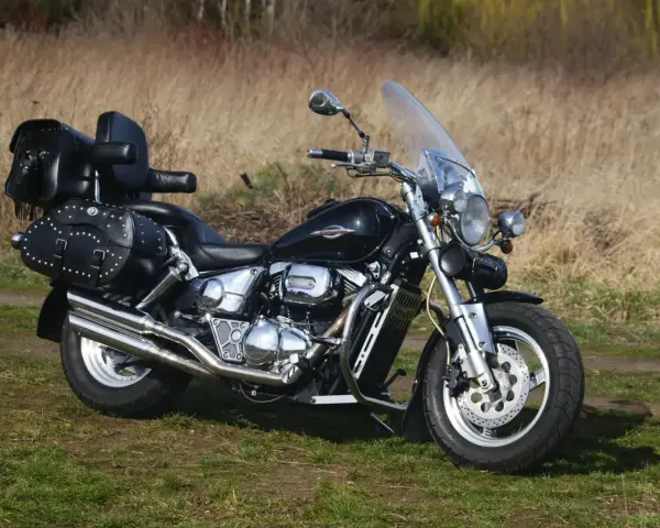 Czarny Suzuki Marauder z sakwami i oparciem, gotowy na podróż przez jesienne krajobrazy.