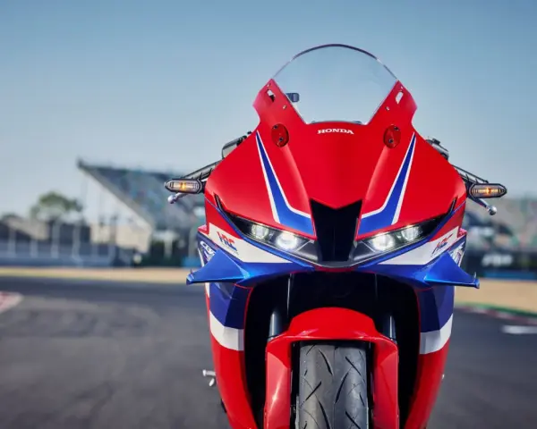 Czerwono-niebieski motocykl Honda CBR 600RR na torze wyścigowym. Poznaj honda cbr 600rr dane techniczne i poczuj moc!