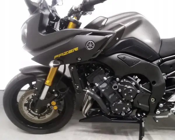 Ciemnoszary motocykl Yamaha FZ8 z żółtym napisem "FAZER" na owiewce. Widoczny silnik i przednie zawieszenie.