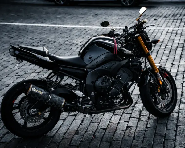 Czarny motocykl na bruku, idealny na giełda motocykli używanych Niemcy. Gotowy do jazdy po niemieckich drogach.