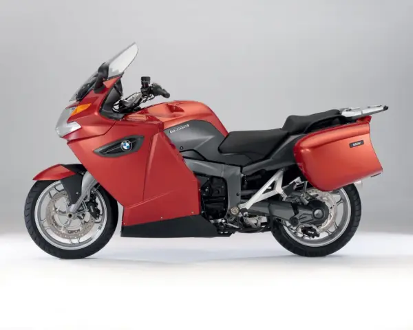 Czerwony motocykl turystyczny BMW K1300GT z kuframi, gotowy na długie podróże.