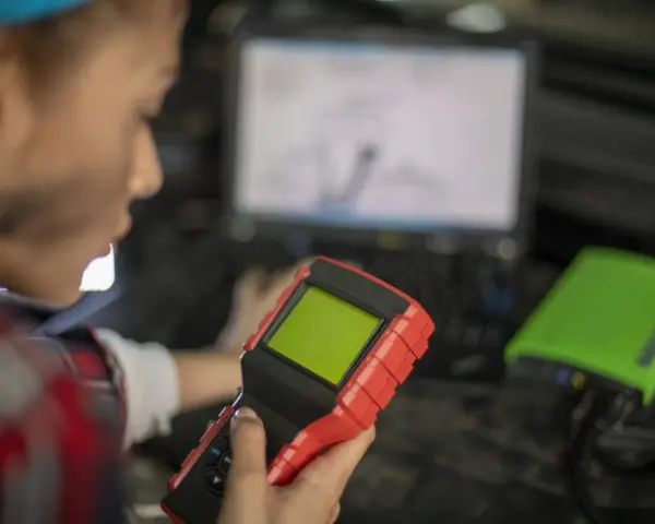 Mechanik z urządzeniem diagnostycznym i laptopem.