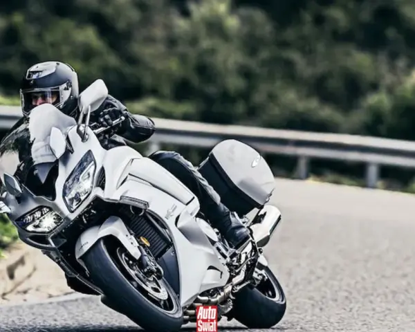 Motocyklista w białym Yamaha FJR 1300 na zakręcie drogi.