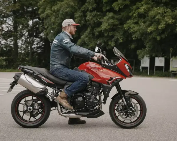 Mężczyzna na czerwonym motocyklu Triumph Tiger 1050. Poznaj jego dane techniczne i możliwości.